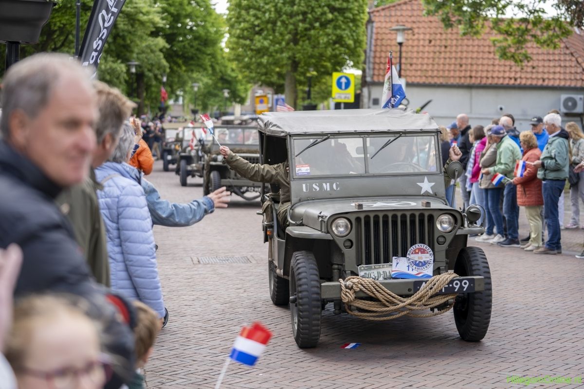 Legerjeep van de Liberation Tour tussen zwaaiend publiek