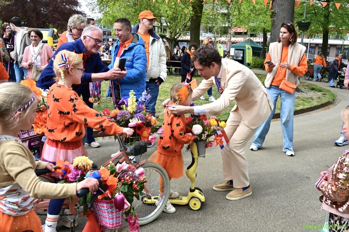 De burgemeester hangt een medaille om bij het kinderbloemencorso