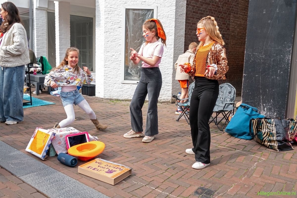 Meisjes dansen op straat bij de vrijmarkt